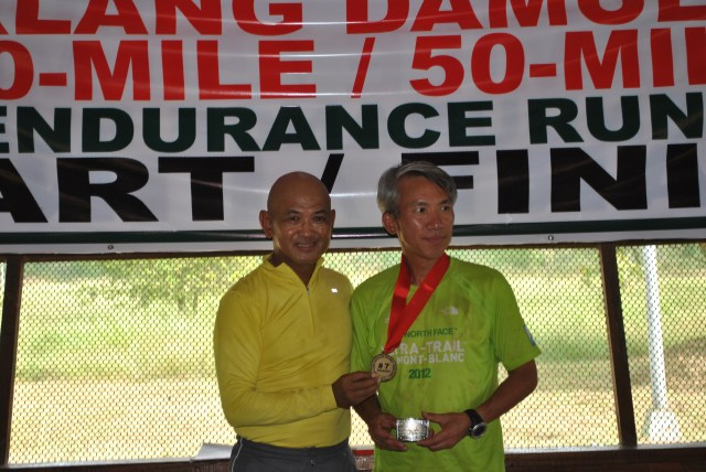 Seow Kong Ng of Malaysia Receiving His Silver Buckle & Finisher's Medal